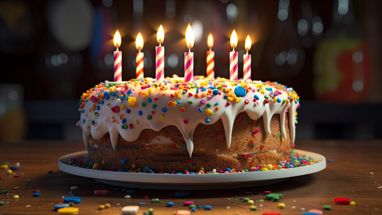 bolo-de-aniversario-com-velas-coloridas-na-mesa-de-madeira-e-fundo-preto-ai-generative