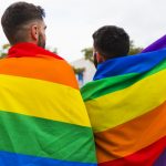 couple-gay-wrapped-lgbt-flags-standing-back