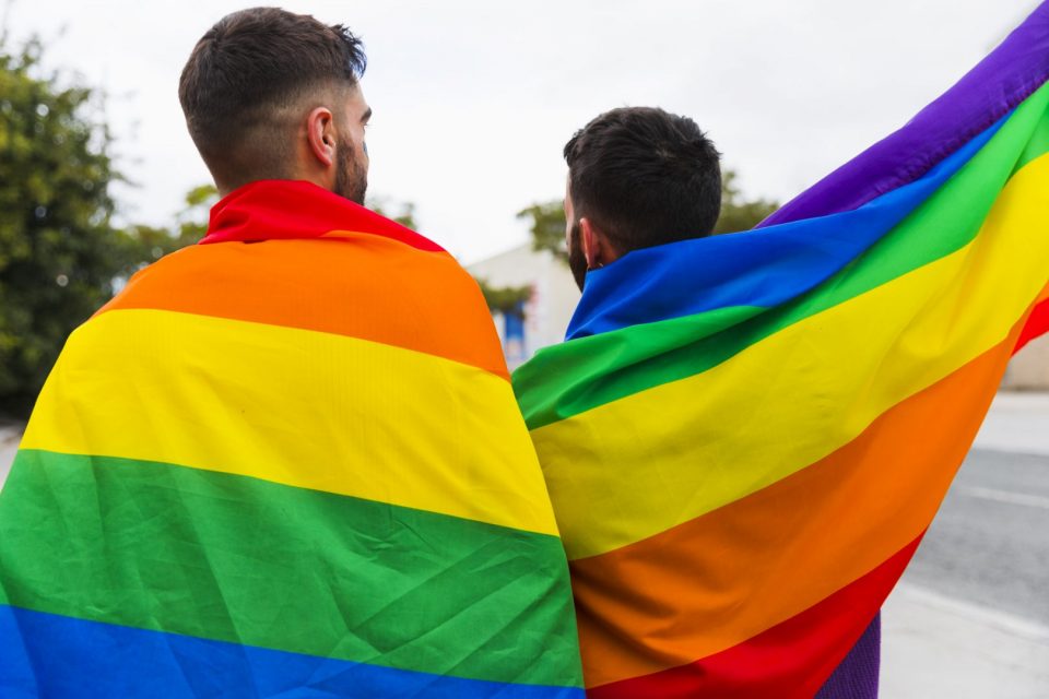 couple-gay-wrapped-lgbt-flags-standing-back