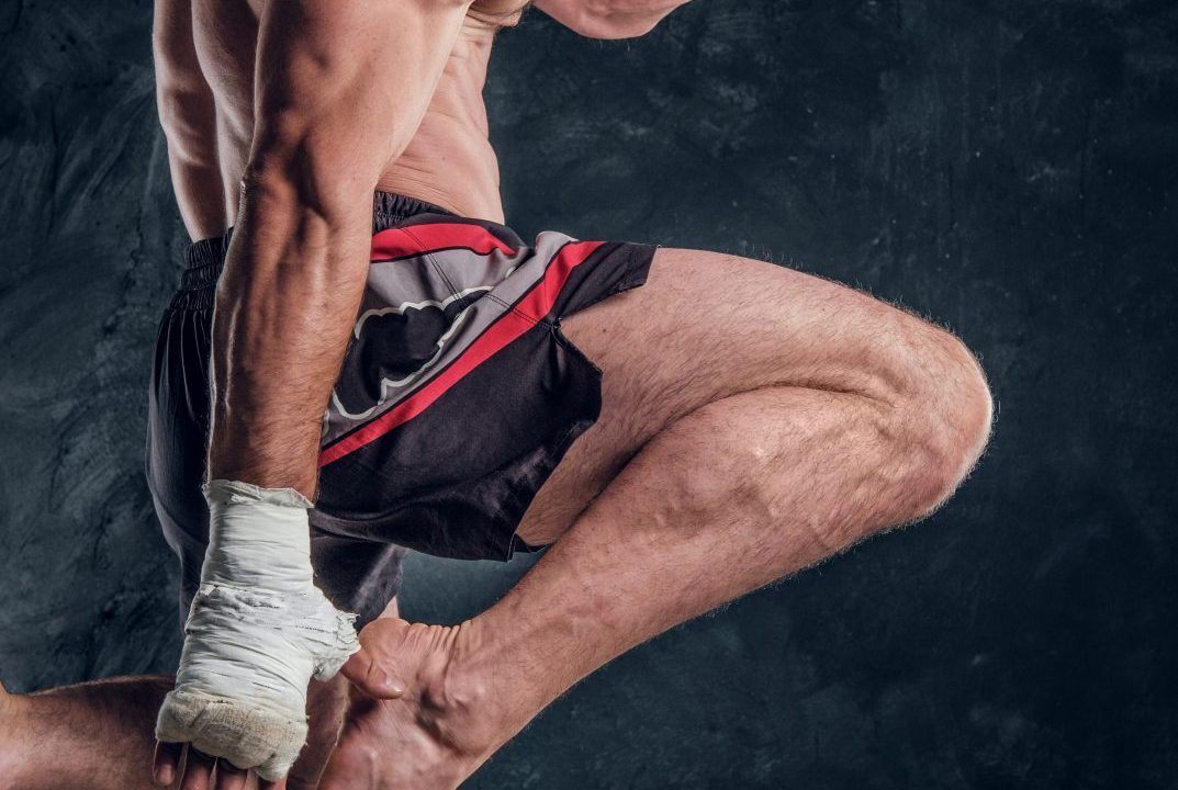 focused-physically-fit-man-is-jumping-making-illusion-flight-before-punch-dark-studio