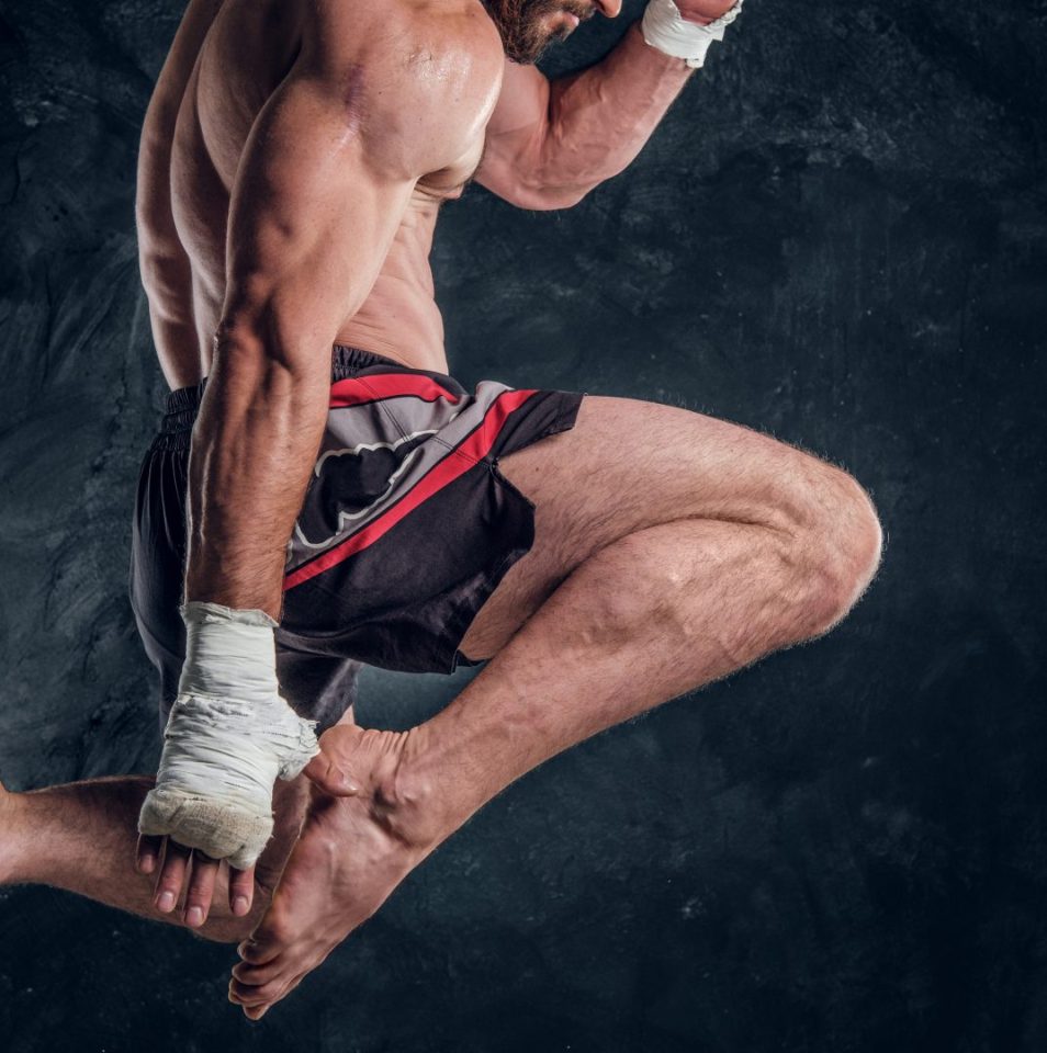 focused-physically-fit-man-is-jumping-making-illusion-flight-before-punch-dark-studio