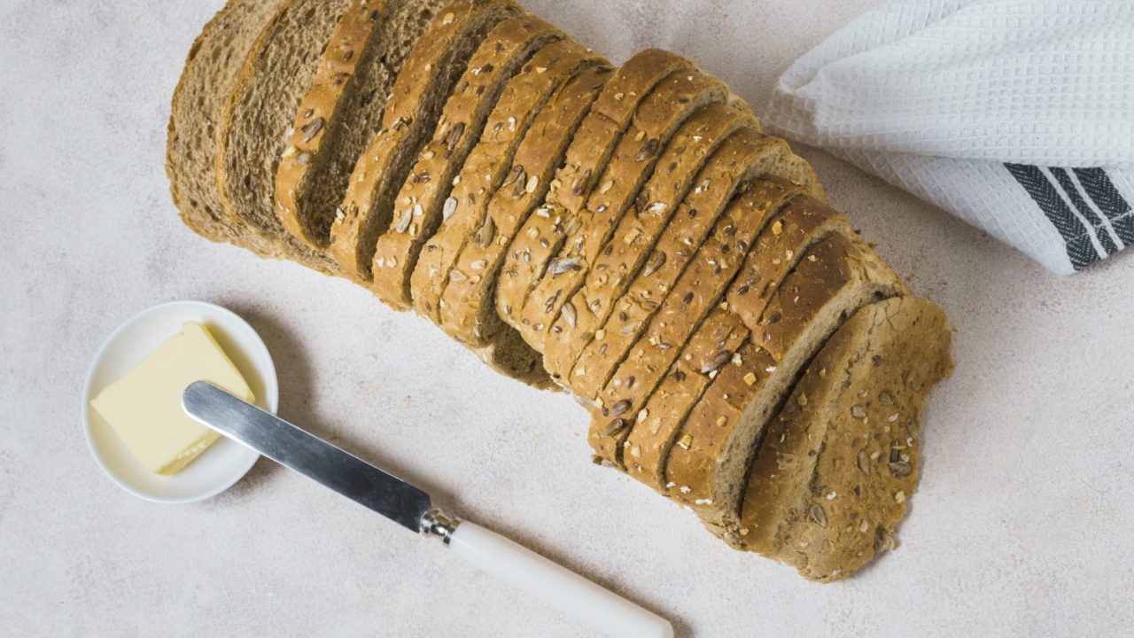 top-view-slices-bread-with-butter-knife