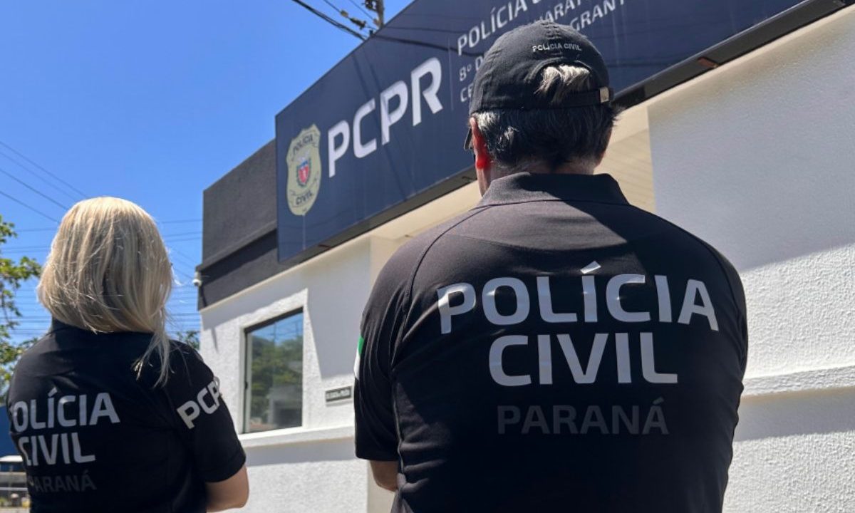 policias de costas em frente a delegacia