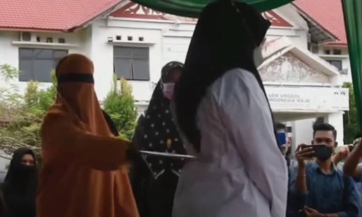 Mulher sendo castigada com chibatadas em praça pública na província de Aceh, na Indonésia