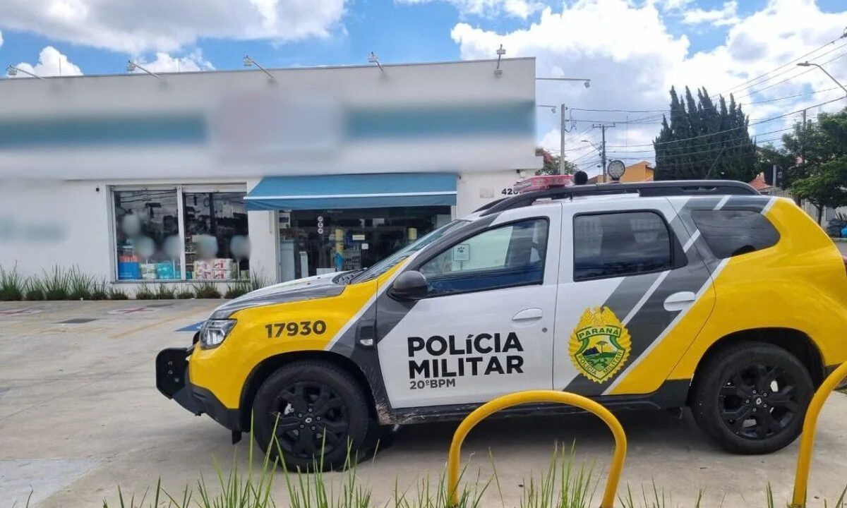 Viatura da Polícia Militar estacionada em frente a uma farmácia após um roubo