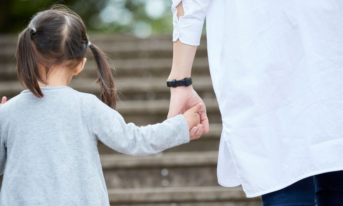 foto de criança segurando mão de um adulto para ilustrar o caso da criança que foi levada por uma família por engano