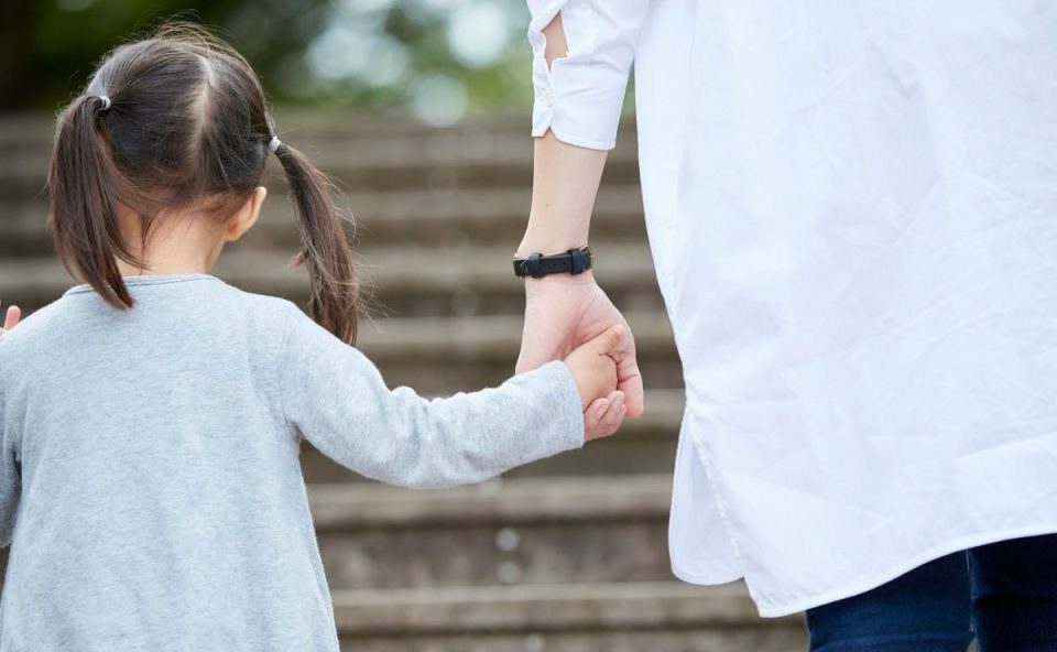 foto de criança segurando mão de um adulto para ilustrar o caso da criança que foi levada por uma família por engano 