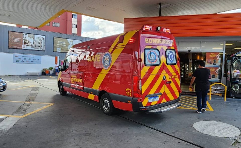 Foto mostra ambulância parada em posto prestando atendimento a homem agredido