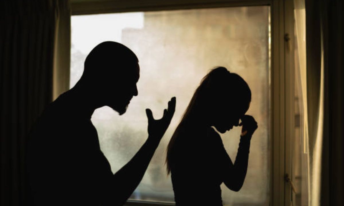 Silhuetas de homem e mulher discutindo dentro de casa