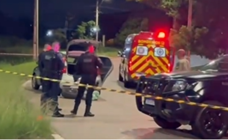 Foto tirada à noite mostra ambulância do Corpo de Bombeiros, viatura da ROMU e carro do suspeito parados em uma rua de Araucária