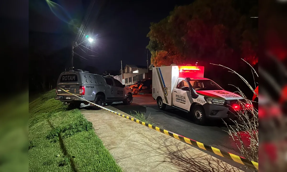Foto mostra duas viaturas, uma escura da Rotam e outra branca da Polícia Científica. A imagem foi tirada à noite, em frente à casa onde houve o confronto