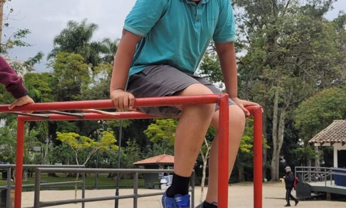 Foto mostra menino brincando em parque, com o rosto cortado para não identificá-lo