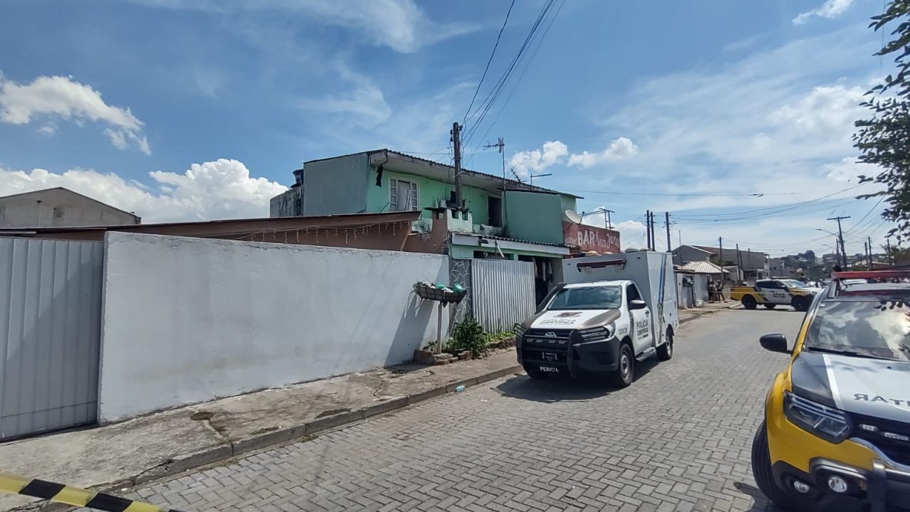Viatura do IML estacionada em frente à residência onde homem foi morto a facadas na Vila Zumbi, em Colombo.