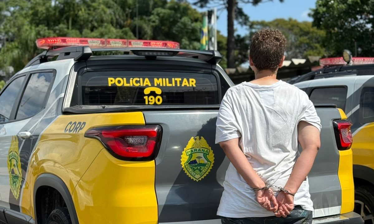 Mulher algemada ao lado de viatura da Polícia Militar após roubo no Parolin
