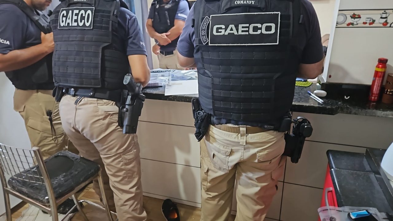 Foto mostra agentes do Gaeco cumprindo mandados de prisão e de busca e apreensão em endereços ligados aos investigados.