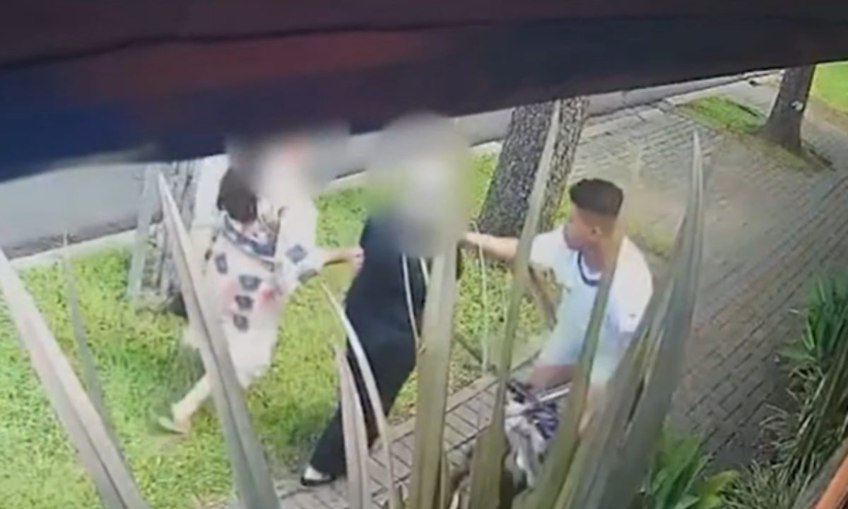Frame de vídeo de segurança mostra jovem de bicicleta se aproximando de vítima antes de furtar correntinha em Curitiba.