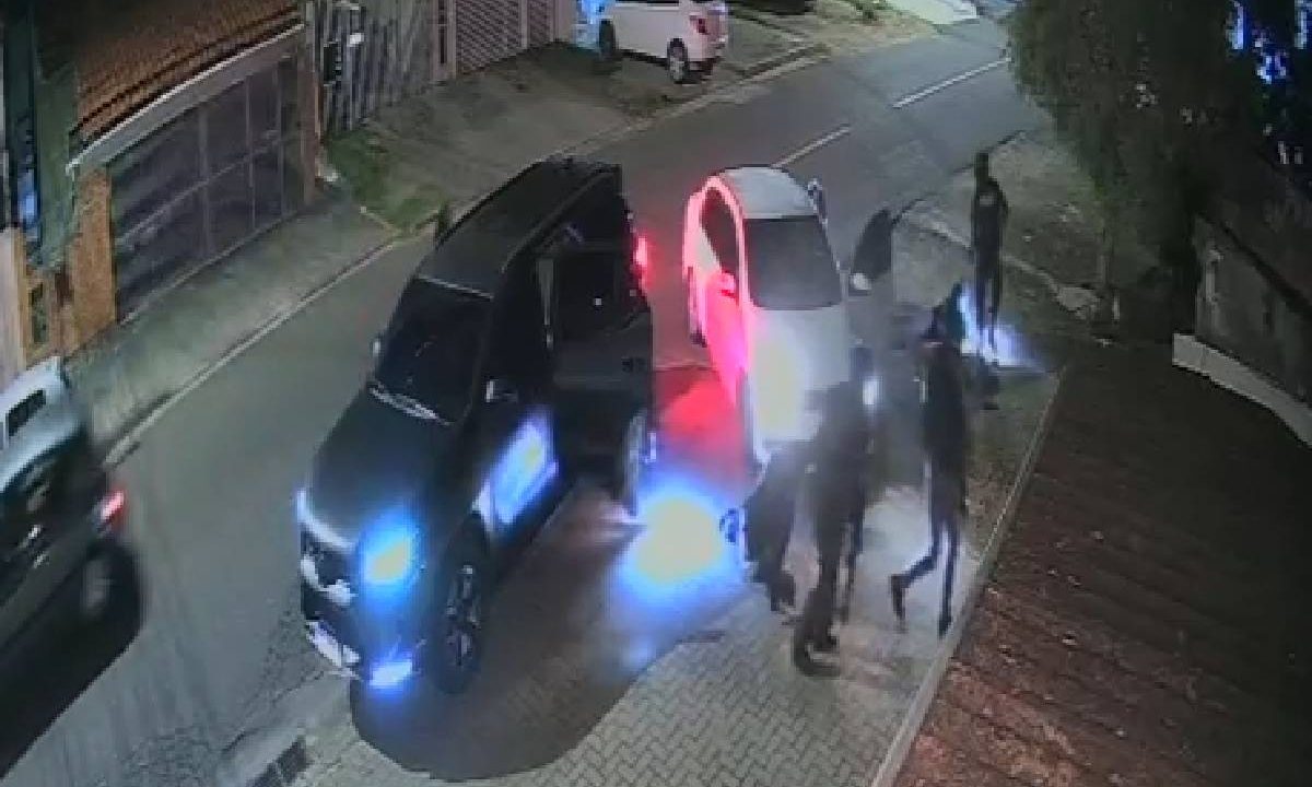 Foto mostra caminhonete para da na rua e criminosos na calçada