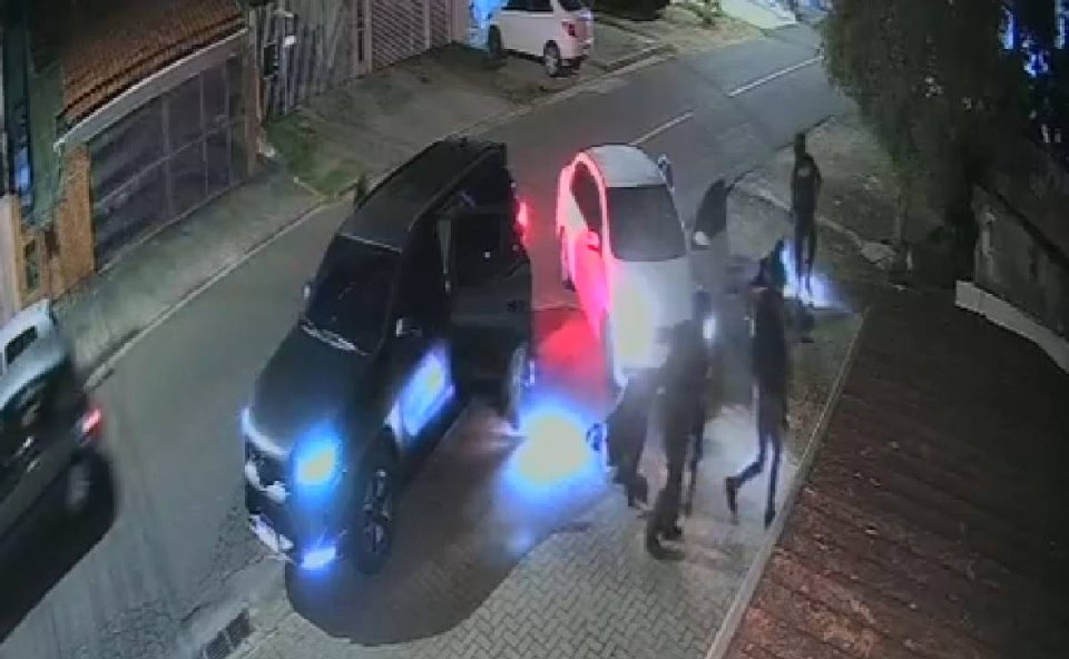 Foto mostra caminhonete para da na rua e criminosos na calçada