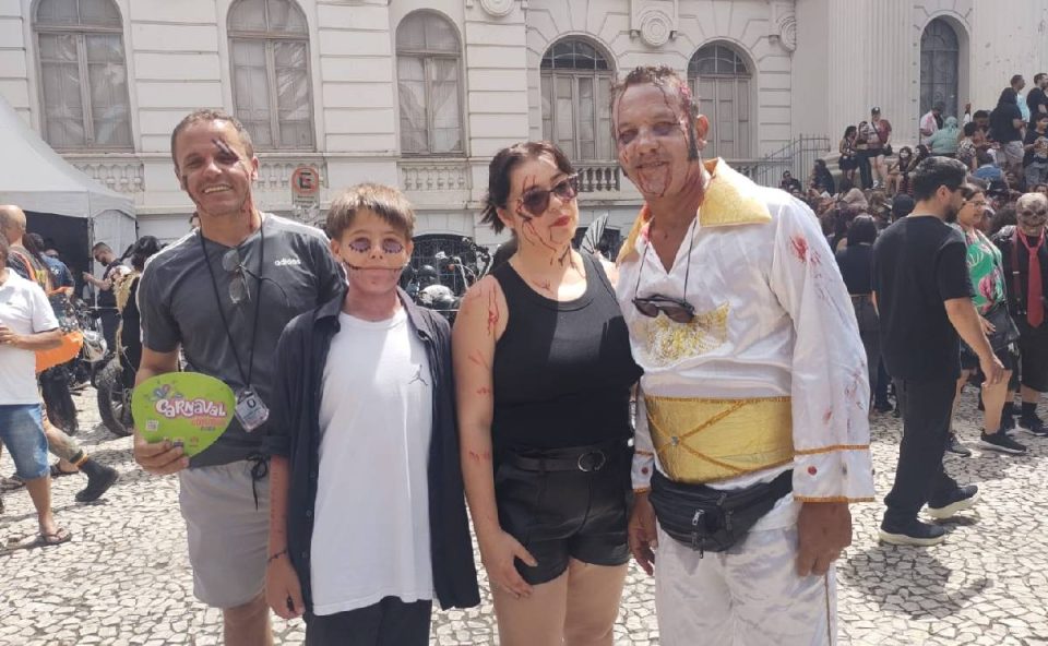 Foto mostra grupo fantasiado e homem vestido de Elvis versão Zombie