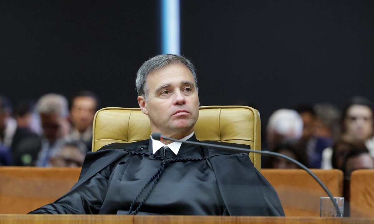 ministro andré mendonça, homem branco de cabelo grisalho, vestindo beca e sentado na cadeira amarela do STF com microfone a sua frente
