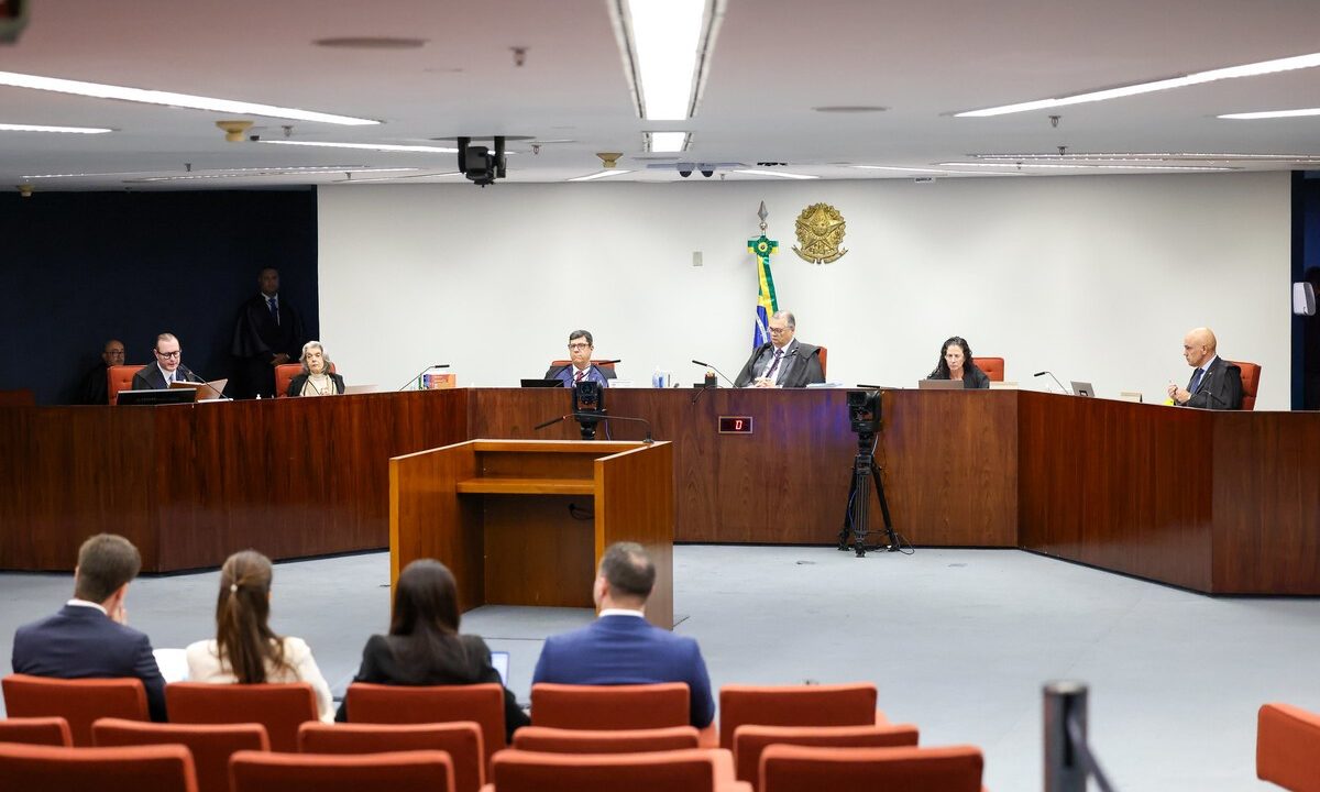 seis pessoas estão atrás da tribuna do STF, entre elas quatro homens de terno e gravata e duas mulheres, uma de cabelo preto e outra grisalho