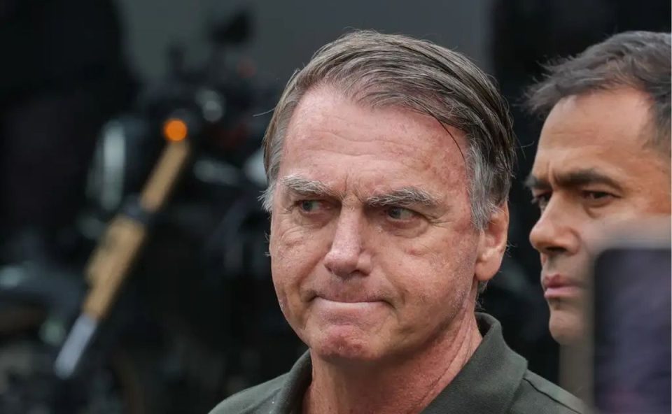 Imagem mostra o rosto de Jair Bolsonaro, apreensivo, enquanto deixa o hospital sob forte esquema de segurança. Moraes negou o pedido da defesa de Bolsonaro para que seus filhos tivessem livre acesso à sua residência durante a prisão domiciliar