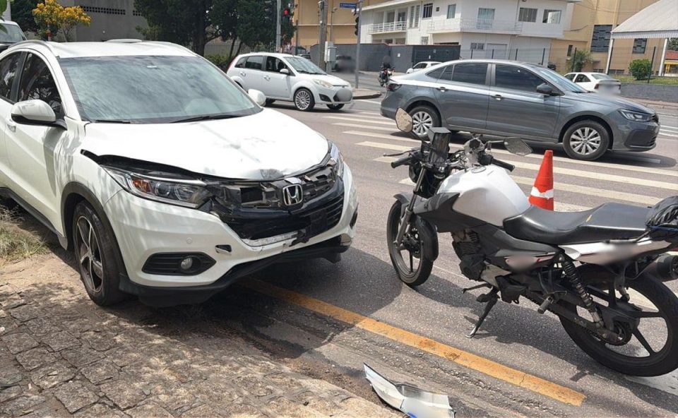 Carro branco com a parte frontal destruída após acidente com uma moto no bairro Novo Mundo.