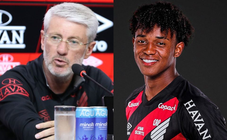 À esquerda, um homem branco, de cerca de 50 anos, com cabelos curtos grisalhos e barba aparada, participa de uma entrevista coletiva. Ele usa óculos de armação fina e veste um agasalho preto com detalhes em vermelho do Athletico. Está sentado diante de um microfone, com um copo de água sobre a mesa, falando com expressão séria e concentrada. À direita, um jovem negro, de aproximadamente 17 anos, aparece em uma foto de estúdio. Ele tem cabelo curto e cacheado, sorri levemente e veste a camisa oficial do Athletico, nas cores preto e vermelho. O fundo é escuro, destacando o uniforme e o rosto do jogador.