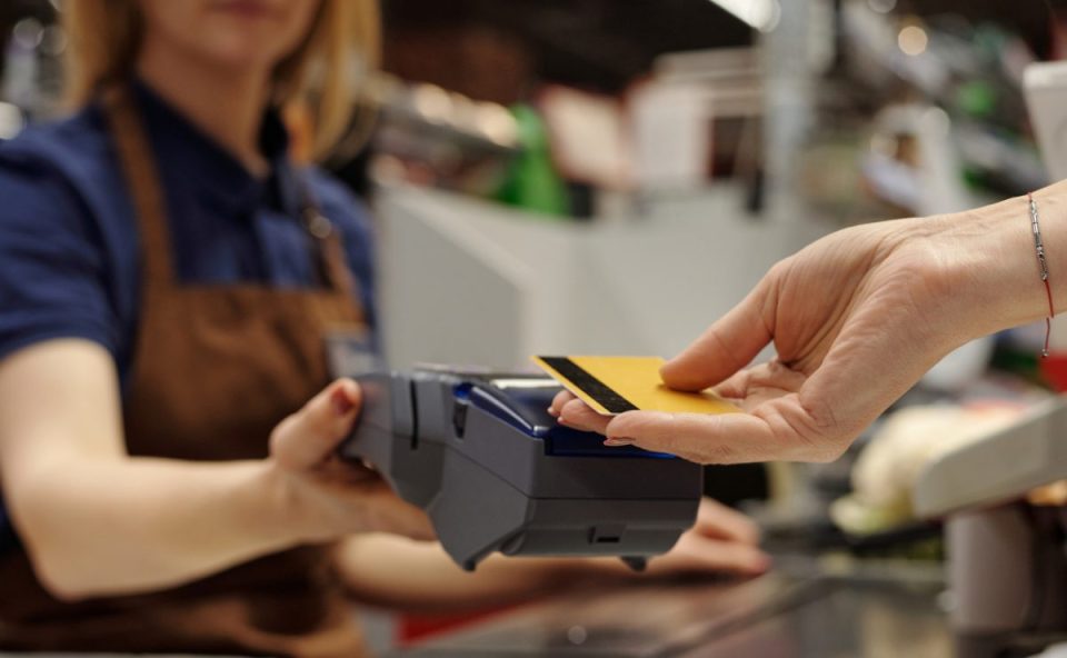 Mulher pagando compra com cartão de crédito; modelo é o maior causador de dívidas entre brasileiros.