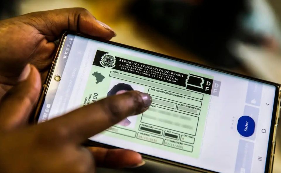 pessoa segurando o celular com o aplicativo da CNH aberto para ilustrar o projeto que autoriza o aumento novo limite de peso