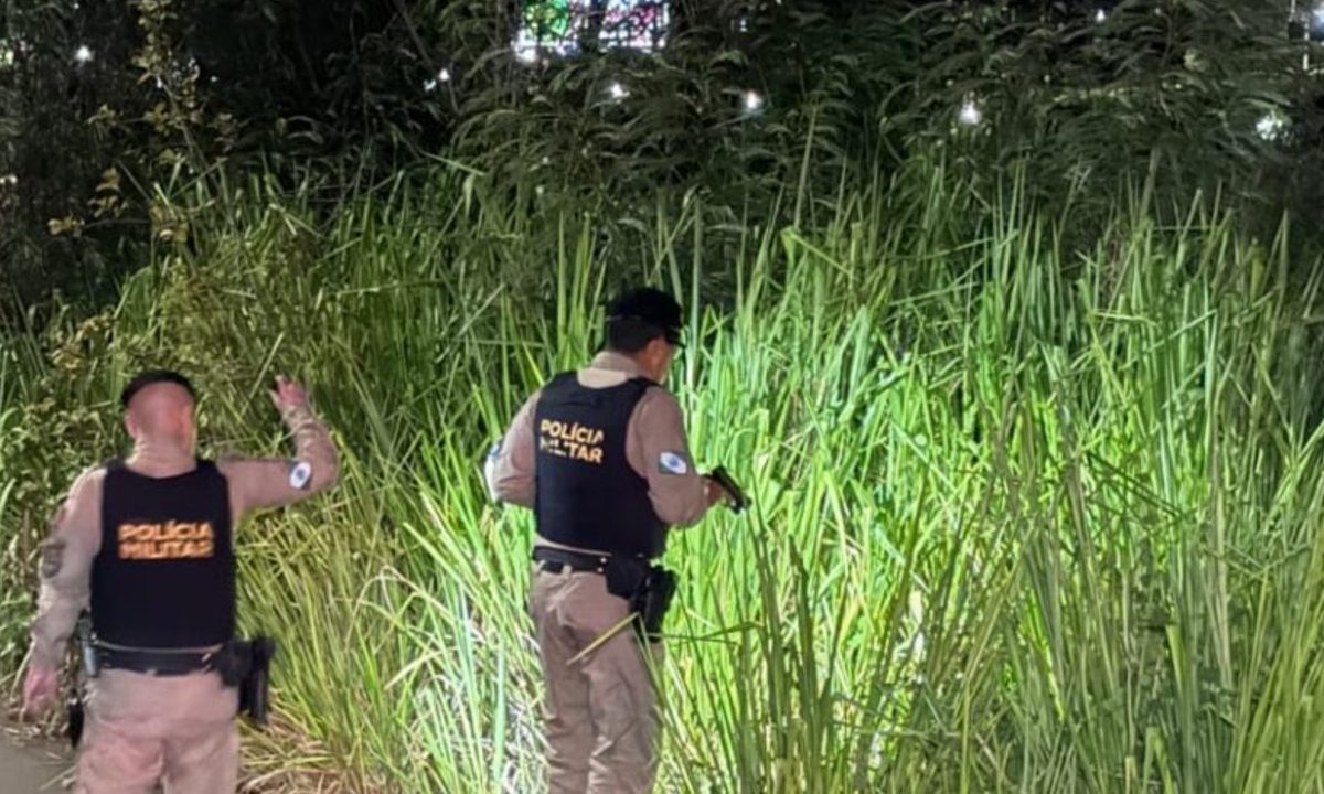 Policiais militares usam lanterna durante atendimento em área de matagal onde um corpo de homem foi encontrado às margens do Contorno Norte, em Maringá.