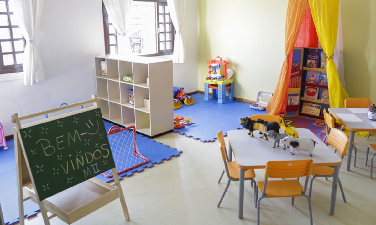 Sala de aula de uma creche em Curitiba e um quadro com a frase 'bem-vindos' escrita com giz de cera. Vagas estão disponíveis.