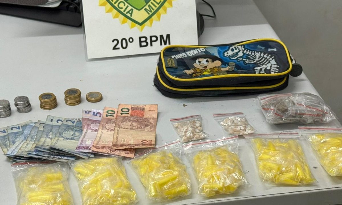 Foto mostra porções de drogas, estojo escolar e dinheiro trocado sobre mesa, após prisão de gerente de biqueira no Boqueirão