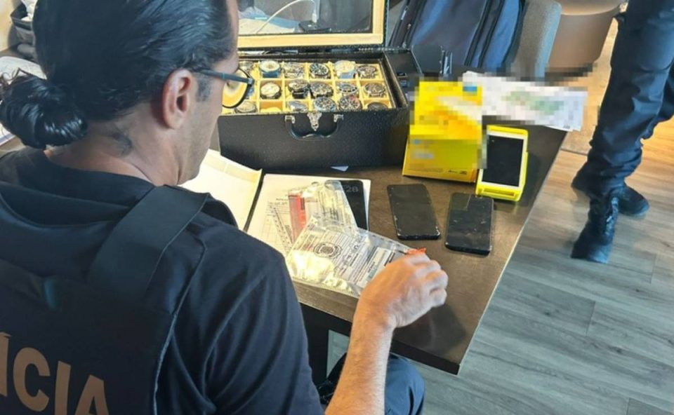 Foto mostra agente da PF analisando itens apreendidos