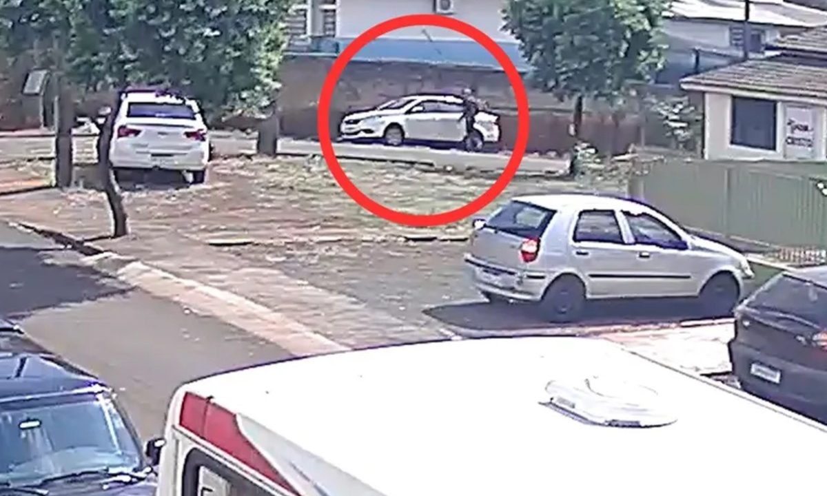 Foto registrada por câmera de segurança mostra momento em que homem ateia fogo em carro de pedagoga, em frente a colégio no Paraná