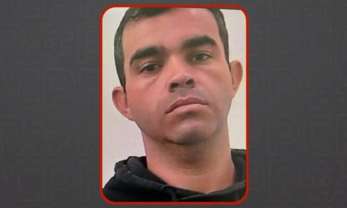 Imagem mostra o homem que atirou na ex-esposa. Ele foi preso. Imagem mostra um homem com cabelo curto, rosto sério e blusa preta.