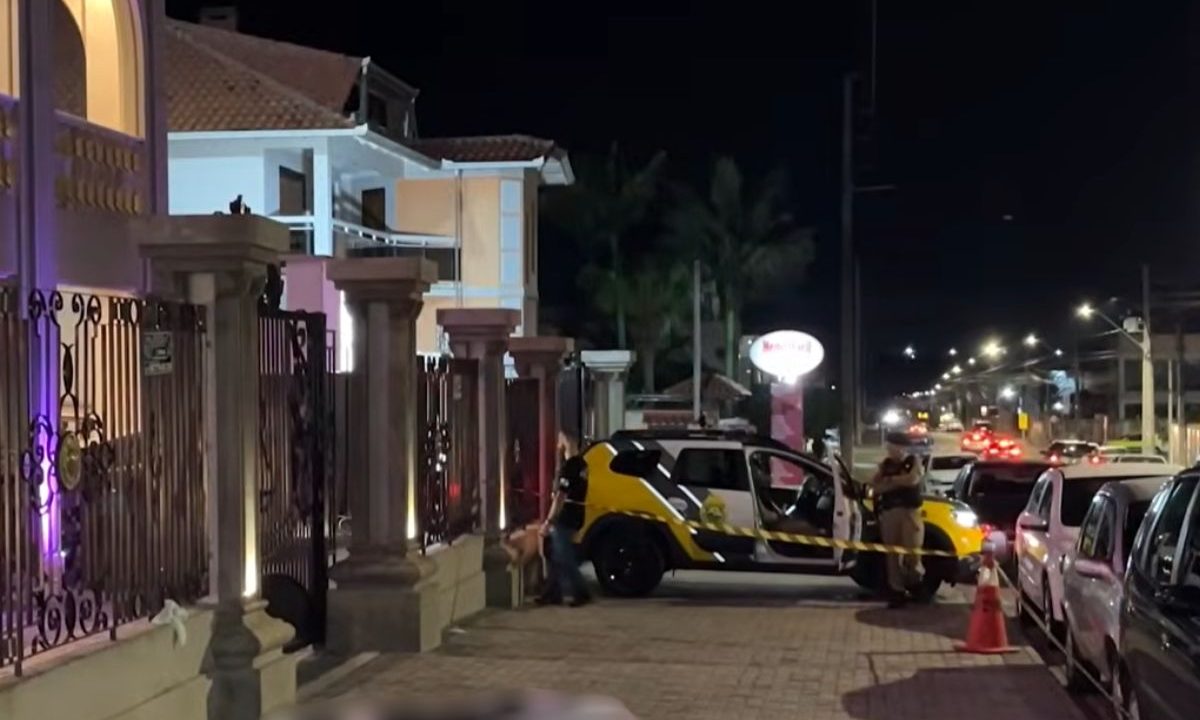 foto do local onde o homem morreu pediu ajuda em uma igreja e morreu. na imagem aparece uma viatura da polícia e o corpo no chão