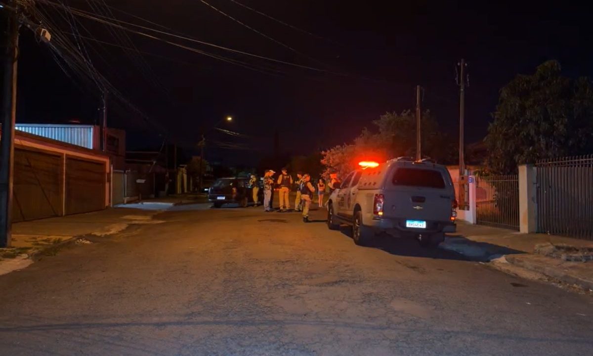 Viatura da Polícia Militar e agentes em atendimento a ocorrência durante a noite em rua residencial de Cascavel