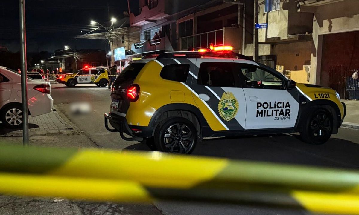 foto do local onde o homem foi morto a tiros em curitiba. na imagem aparece viatura da polícia eo local isolado
