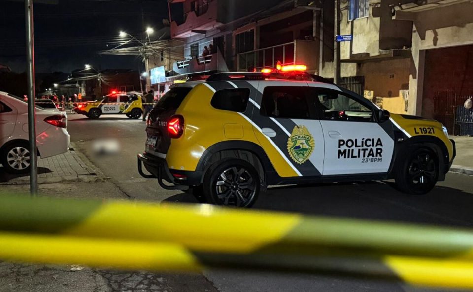 foto do local onde o homem foi morto a tiros em curitiba. na imagem aparece viatura da polícia eo local isolado