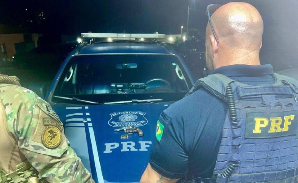 Foto mostra agentes da PRF com arma utilizada pelos suspeitos de sequestrar homem