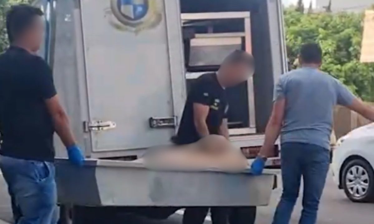Polícia recolhendo corpo de idosa encontrada morta em apartamento.
