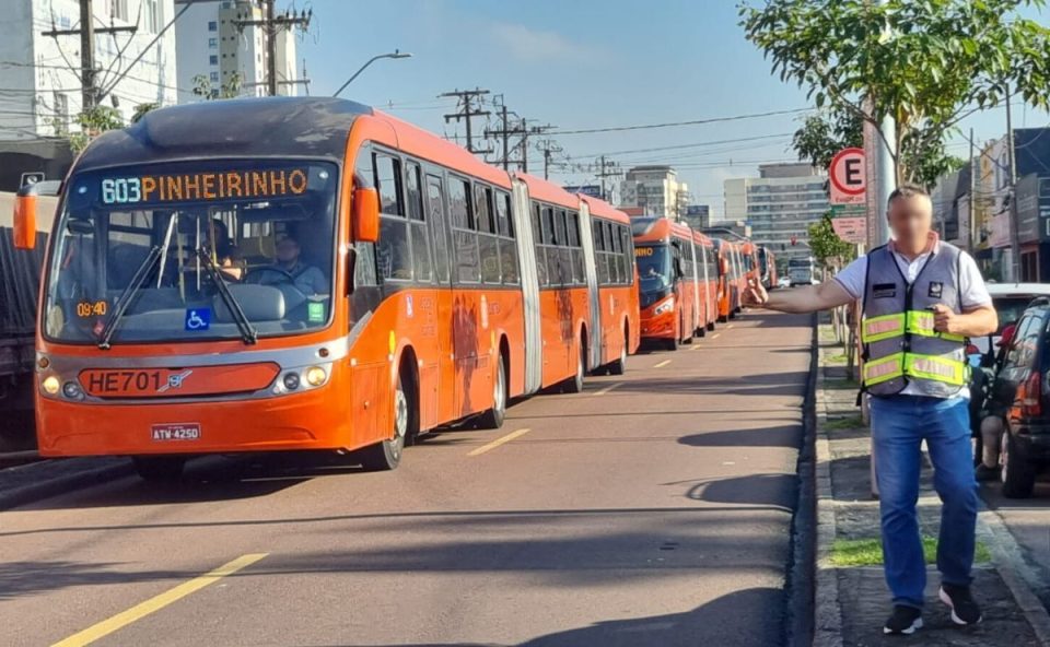 foto do local onde o idoso foi atropelado por um ônibus biarticulado em curitiba no terminal do capão raso. a imagem mostra diversos ônibus parados devido ao acidente