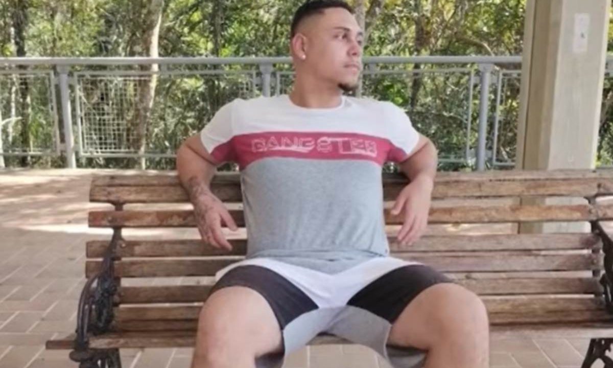 jovem executado no sítio cercado sentado no banco