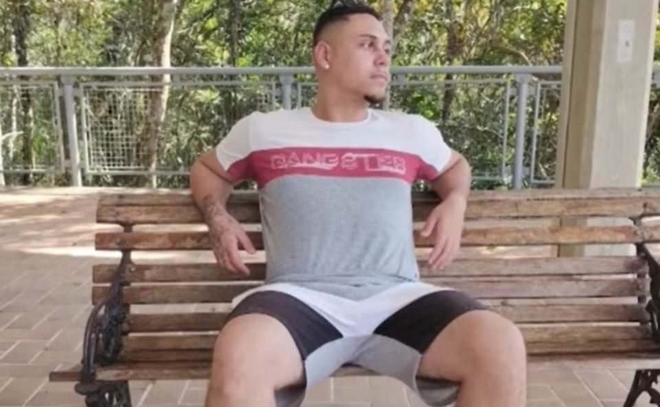 jovem executado no sítio cercado sentado no banco