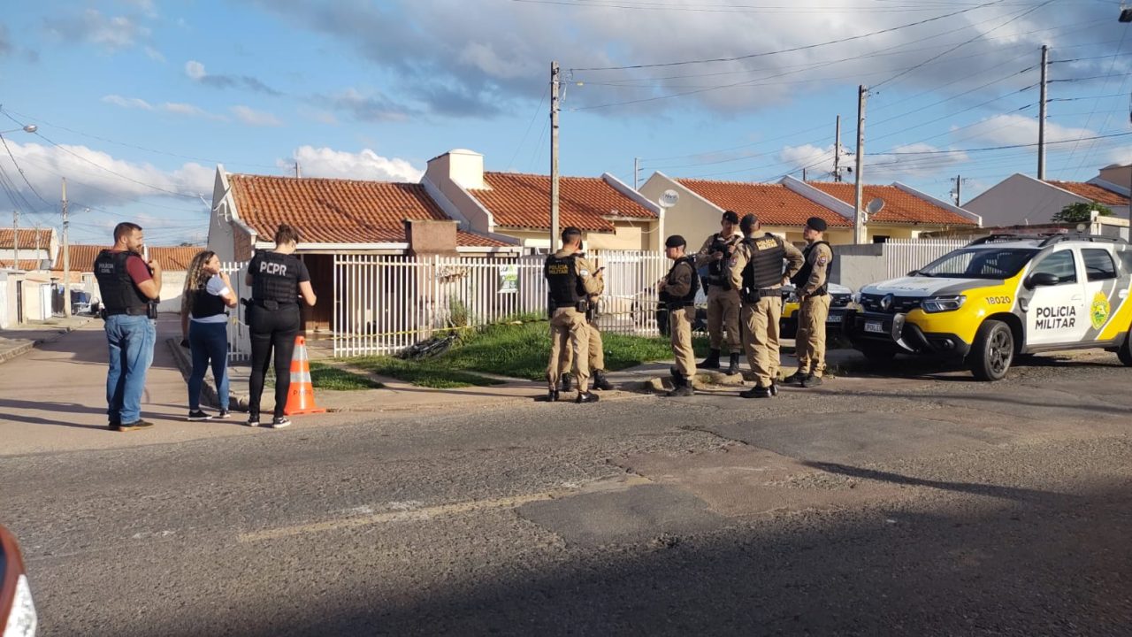 Policiais militares e civis em frente à casa onde jovem foi morta em Fazenda Rio Grande.