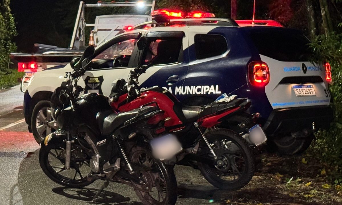 Duas motos furtadas recuperadas após furto na UPA Boqueirão aparecem ao lado de viatura da Guarda Municipal durante a noite, em Curitiba.