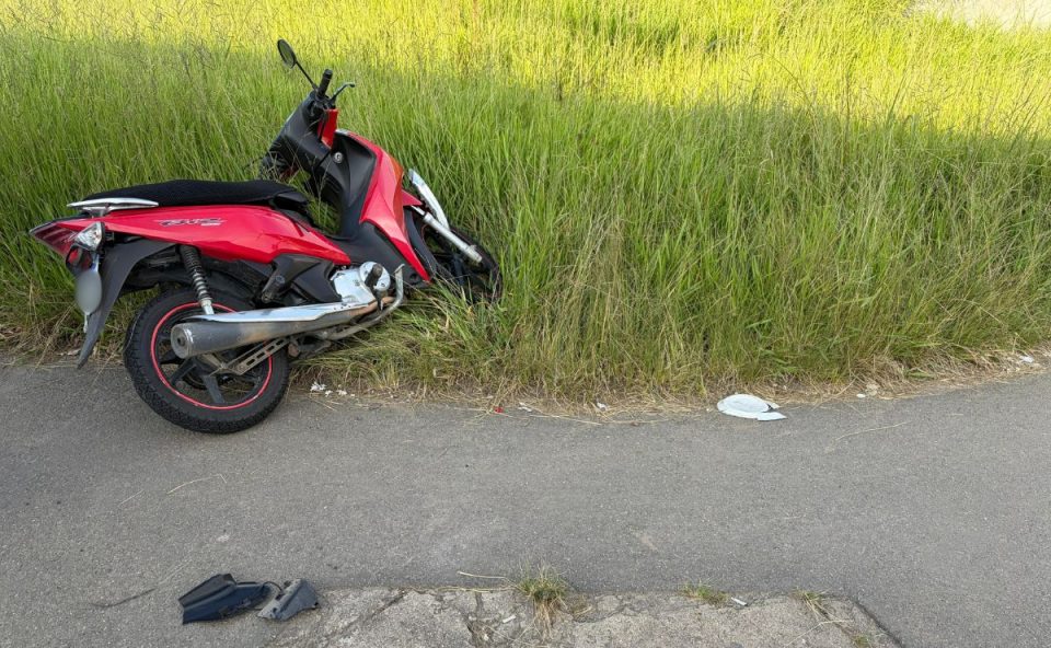 foto da moto do motociclista que ficou ferido no acidente em curitiba. a imagem mostra o veículo caído sobre a grama 
