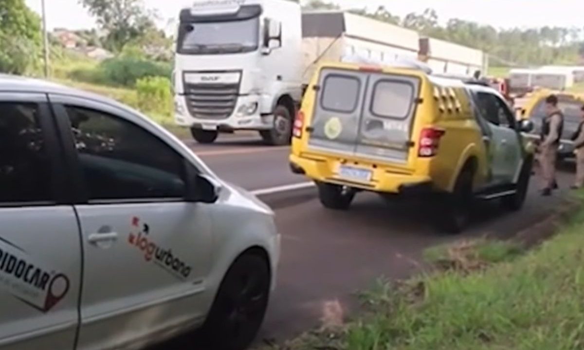 foto do local onde o motorista sequestrado foi encontrado. na foto aparece o carro da vítima e uma viatura da polícia militar
