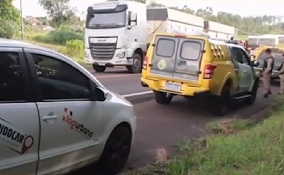 foto do local onde o motorista sequestrado foi encontrado. na foto aparece o carro da vítima e uma viatura da polícia militar 